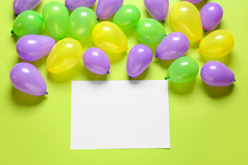 Blank paper sheet and air balloons on color background