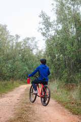 Fototapeta premium Young man on his bike on a forest road, playing sports in nature.