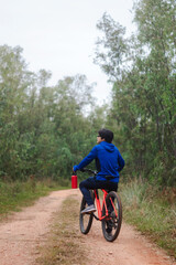 Young man on his bike on a forest road, playing sports in nature, active lifestyle.