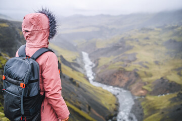 Close up of a woman with backpack enjoying icelandic highland and river fossa close to Haifoss waterfall in Iceland