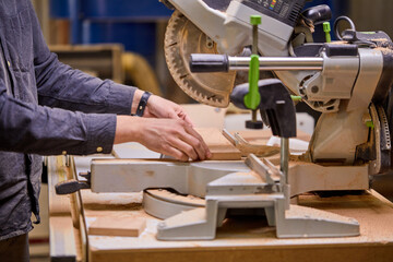 Carpenter using electric woodworking. close-up hands using electric equipment machine. Routing is a high speed process of cutting, trimming, and shaping wood