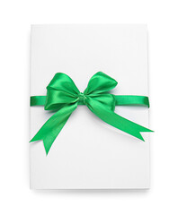 Blank sheet of paper with green ribbon and bow on white background