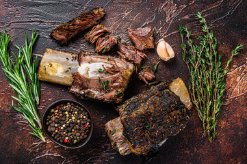 BBQ Grilled short beef ribs on a kitchen table. Dark background. Top view