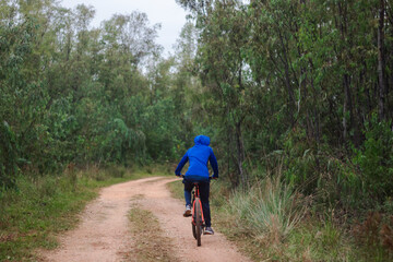 Young man riding a bike on a forest road, active lifestyle.