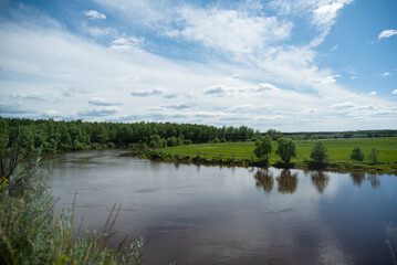 Fototapeta na wymiar Flowing water of the river under summer blue sky landscape background.
