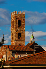 View of the Church of Saints John and Reparata medieval bell tower and dome among clouds rises above Lucca charming historic center roofs - obrazy, fototapety, plakaty