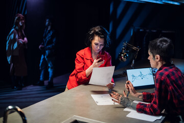 A tattoo master with face tattoos and piercings creates a unique tattoo sketch for her girlfriend. Photographs a sketch on a smartphone.