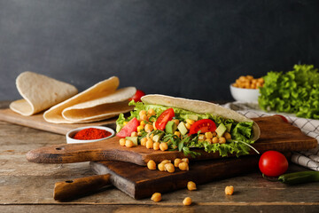 Boards with tasty vegetarian taco on dark background