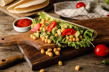 Boards with tasty vegetarian taco on wooden background, closeup