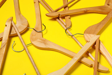 Stylish clothes hangers on color background, closeup