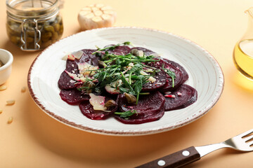 Plate with delicious beetroot carpaccio on color background
