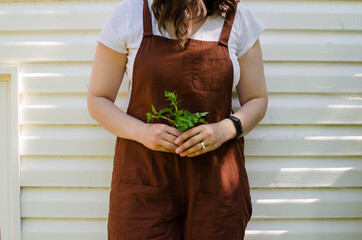 Woman in brown overalls gardening in nature © Claudia