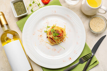 Composition with tasty pasta and bottle of wine on light background