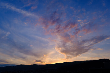 Fototapeta na wymiar 日の入り前の六甲山。西の空と雲がオレンジ色に染まるマジックアワー。１日の終わり。