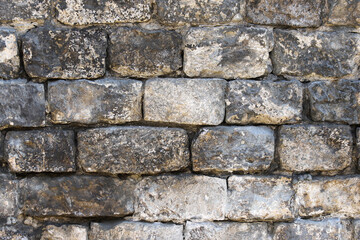 Old wall made of rough stone blocks as a background
