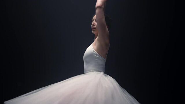 Sensual ballerina rehearsing ballet steps. Ballet dancer dancing indoors.