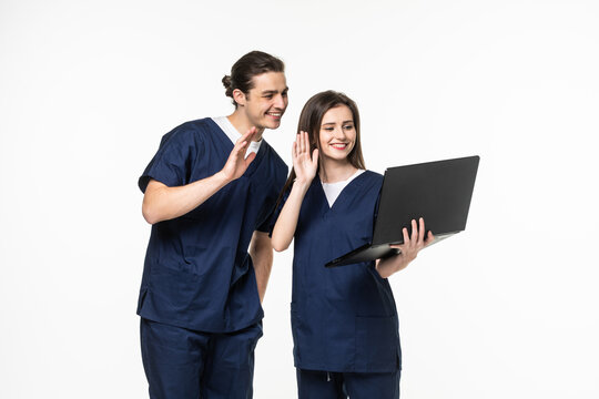 Male And Woman Doctors Using Video Chat On Laptop Against White Background