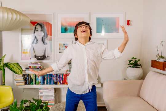 Teen Boy dancing and singing by colorful wall gallery