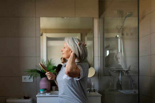 Mature woman brushing her hair