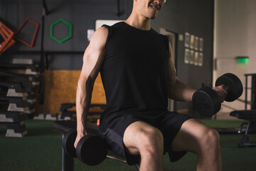 Muscular man training free weight at the gym