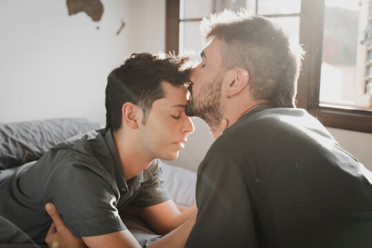 Same sex couple kissing lying on the bed. 