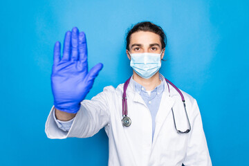 Handsome bald doctor man with beard wearing glasses and stethoscope over blue background doing stop sing with palm of the hand.