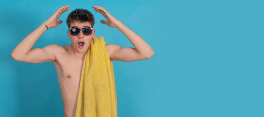 young teenager or student isolated with sunglasses and beach or pool towel surprised