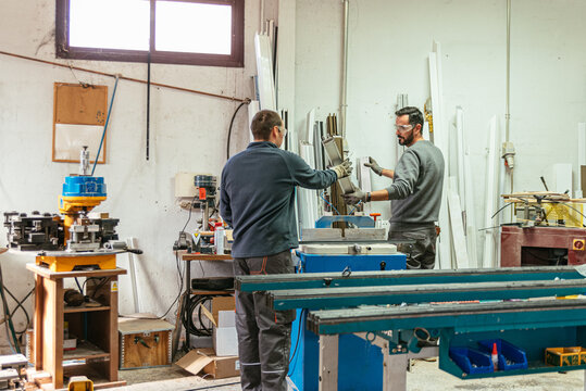 Crop male workers cutting metal in workshop