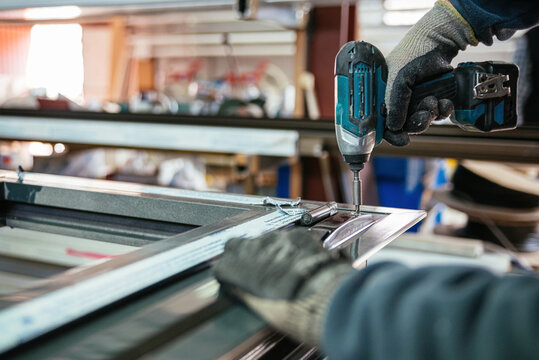 Crop master using screwdriver on aluminum window frame