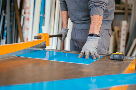 Male workers cutting metal at workbench at factory