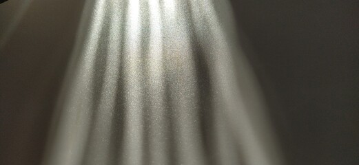 Abstract white gray background. Oblique light rays on a gray background with flickering dots. From...