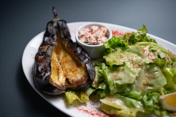 closeup of baked eggplant with chinese cabbage and sauce on black background