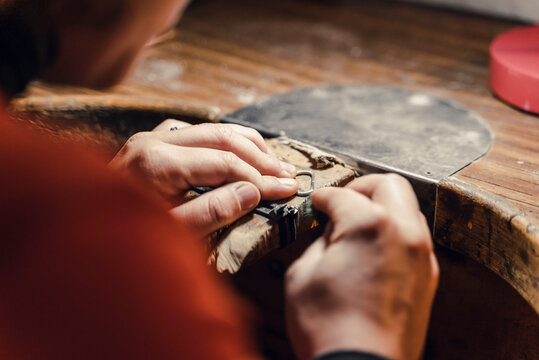Woman working with tools in artisan workshop.