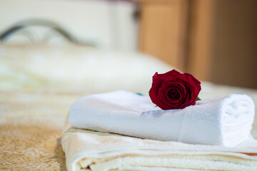 a red rose on the bed towel for holiday guests