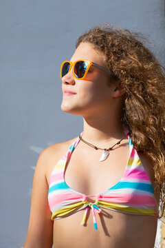 Teen girl portrait on vacation posing with sunglasses and swimwear