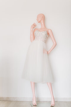 Mannequin wearing a wedding dress against white wall