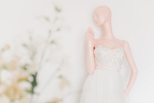 Mannequin wearing a wedding dress against white wall