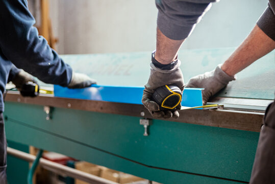 Crop worker using measuring tape at factory in a bending machine