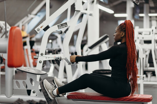 Black woman doing exercises on rowing machine