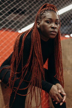 Serious black woman in sportswear in gym looking at camera