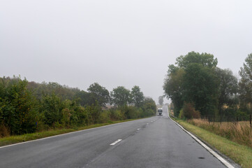 Fototapeta na wymiar Driving on asphalt road in cloudy rainy day