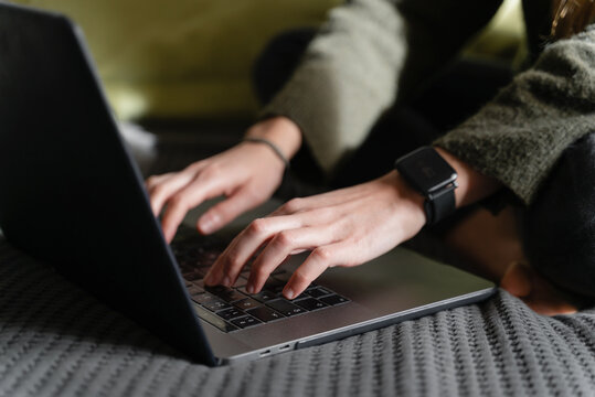 Woman working on laptop on bed