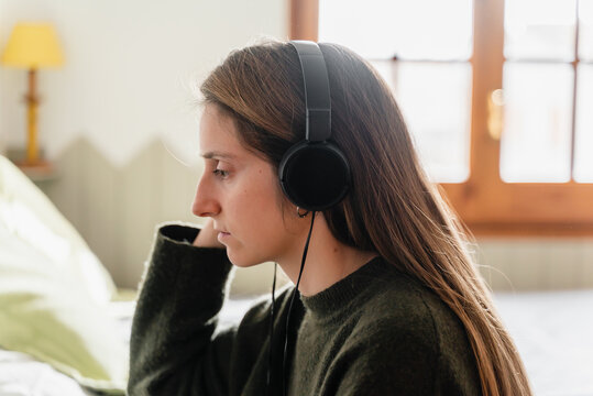 Young woman wearing headphones at her home office