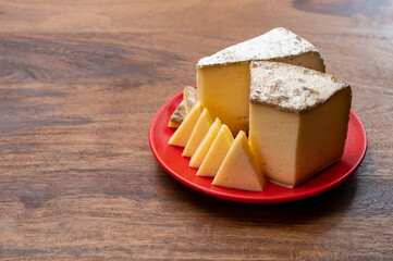 Cheese collection, Tomme de Savoie cheese from Savoy region in French Alps,  mild cow's milk cheese with beige interior and thick brownish-grey rind