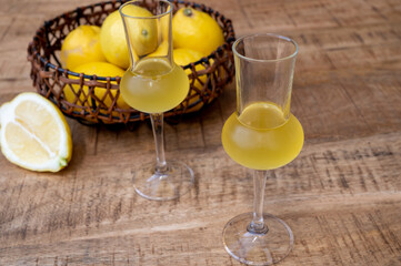 Glasses of cold sweet italian strong alcoholic liquor limoncello made from fresh lemons.
