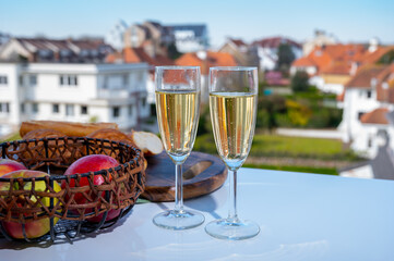 Drinking of brut champagne sparkling wine in flute glasses on outdoor bistro terrace in France