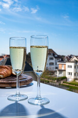 Drinking of brut champagne sparkling wine in flute glasses on outdoor bistro terrace in France