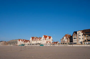 Yellow sandy beach in small Belgian town De Haan or Le Coq sur mer, luxury vacation destination, summer holidays