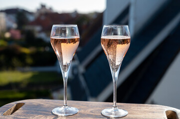 Drinking of rose champagne sparkling wine from flute glasses on outdoor terrace in France