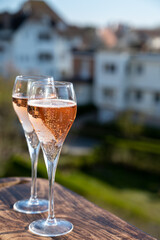 Drinking of rose champagne sparkling wine from flute glasses on outdoor terrace in France